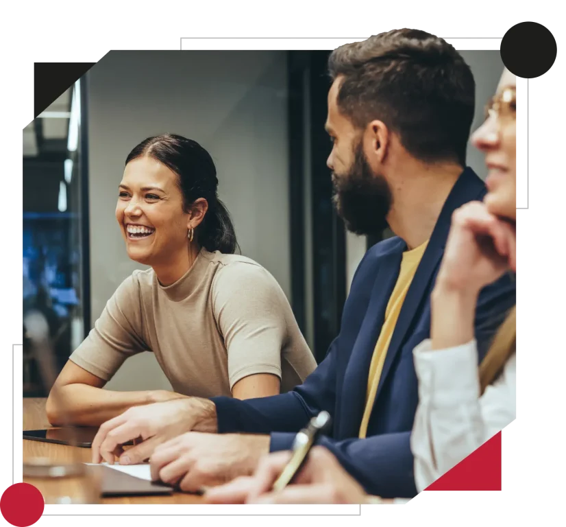 Happy businesswoman laughing while leading a meeting with her colleagues. Group of diverse businesspeople working together in a modern workplace.